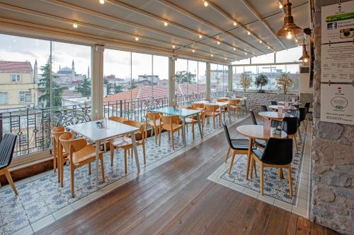 ein Restaurant mit Tischen und Stühlen auf einem Balkon in der Unterkunft Nowy Efendi Hotel - Special Category in Istanbul