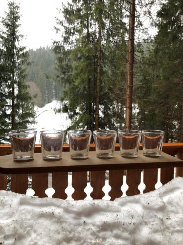 a group of glasses sitting on a table in the snow at Chalupa na Leskové in Velké Karlovice