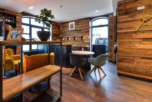 a bar with a table and chairs in a room at HHotel Augsburg in Augsburg