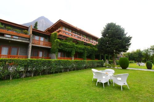 two chairs and a table in front of a building at Gilgit Serena Hotel in Gilgit