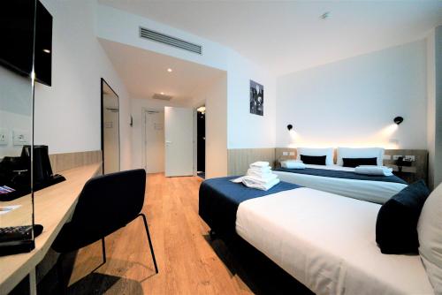 1 dormitorio con 2 camas y escritorio con ordenador en Air Rooms Rome Airport by HelloSky en Fiumicino