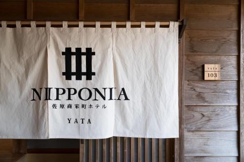 a white curtain with the nipponota sign on it at NIPPONIA Sawara Merchant Town Hotel in Katori