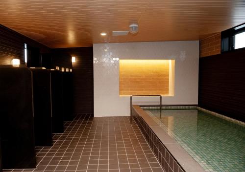 a bathroom with a swimming pool and a window at Shibetsu Grand Hotel in Shibetsu City