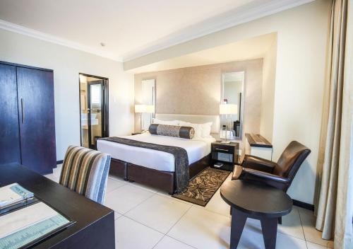 Habitación de hotel con cama y escritorio en Blue Waters Hotel en Durban