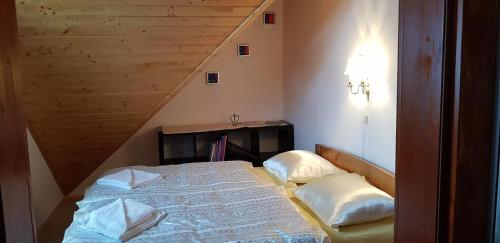 a small bedroom with a bed with a staircase at Hilltop Guesthouse in Brădeşti