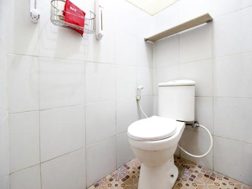 RedDoorz Plus near Stadion Mandala Krida في يوغياكارتا: حمام مع مرحاض أبيض في الغرفة