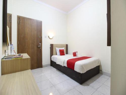 Un pat sau paturi într-o cameră la RedDoorz Plus near Stadion Mandala Krida