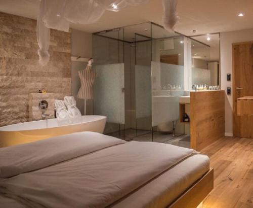 a large bathroom with a tub and a sink at Hotel Waldvogel in Leipheim