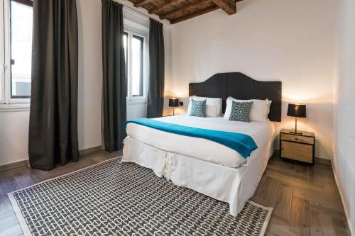 a bedroom with a large bed with blue and white pillows at Globus Urban Hotel in Florence
