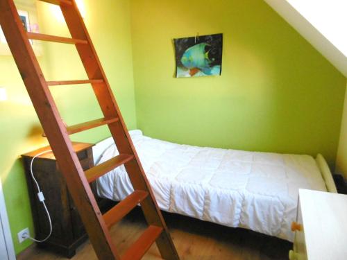 a bedroom with a ladder next to a bed at Maisonnette Solenn in Sarzeau