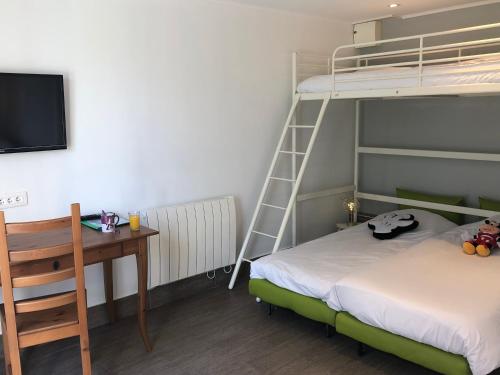 a bedroom with a bunk bed and a desk with a desk at Chambres d'Hôtes Poirier Bazin in Montry