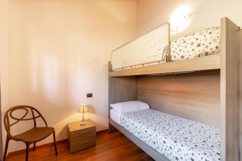 een kleine slaapkamer met een stapelbed en een stoel bij Lazy Bee Camping Village in Aosta