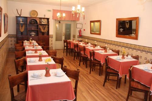 a restaurant with tables and chairs with red tablecloths at Residencial Carvalho in Estremoz