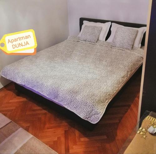 a bed in a room with a sign that says apartment burial at Apartman DUNJA in Vranje