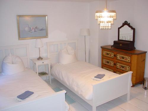a bedroom with two beds and a mirror and a dresser at Robert's Bed & Breakfast in Helmarshausen