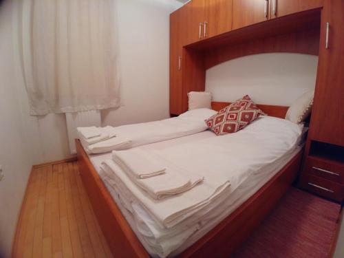 a bedroom with a large bed with a wooden headboard at Apartment Panorama 1 in Vlasic