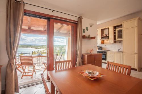 - une cuisine avec une table et une vue sur l'océan dans l'établissement Maestrale Flat - Klodge, à Olbia