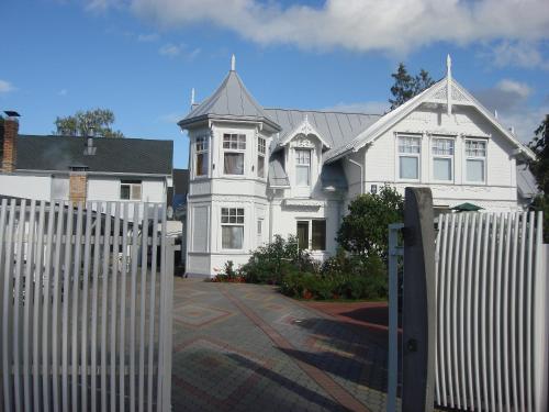 a white house with a fence in front of it at Naiza Guesthouse and Apartments in Jūrmala