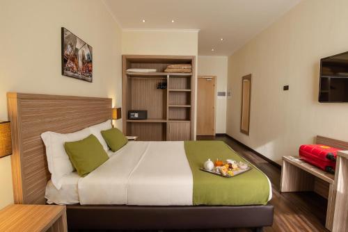 Hotel Roma Sud في فراسكاتي: غرفة نوم بها سرير عليه صينية طعام