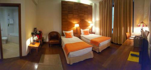 a hotel room with two beds and a bathroom at Rembrandt Old Town in Bucharest