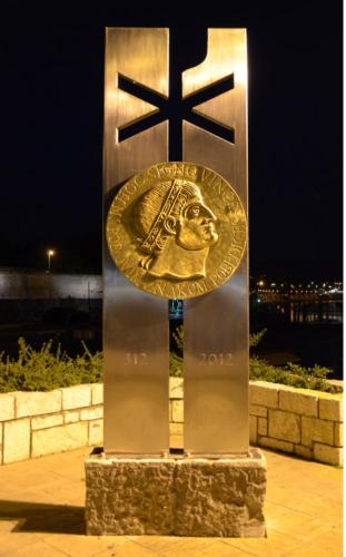 a metal cross with a gold coin on it at Apartments & Dream Rooms in Niš