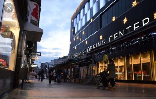 a street with people walking in front of a store at Apartments & Dream Rooms in Niš