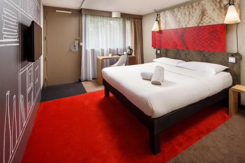 a hotel room with a large bed and a red carpet at ibis Birmingham Centre Irving Street in Birmingham