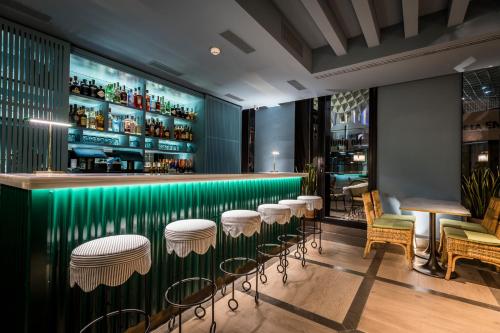 a green bar with stools and tables and chairs at Intelier Casa de Indias in Seville