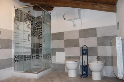 a bathroom with a glass shower and a toilet at Sa Domu Beccia B&B in Uras