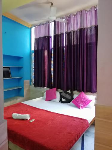 a bedroom with a large bed with purple curtains at Royal Heritage Guest House in Jodhpur