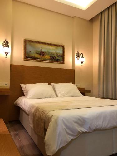 a bedroom with a bed with a painting on the wall at Ottoman's Pearl Hotel in Istanbul