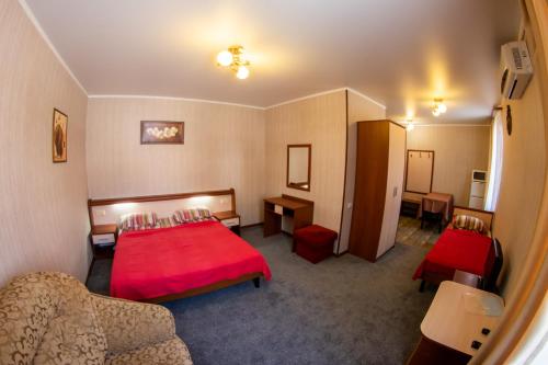 カバルジンカにあるGuest house Alpinaの赤いベッドとソファが備わるホテルルームです。