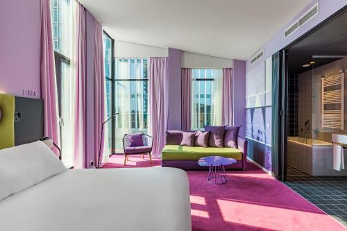a bedroom with a bed and a living room at Room Mate Bruno, Rotterdam in Rotterdam