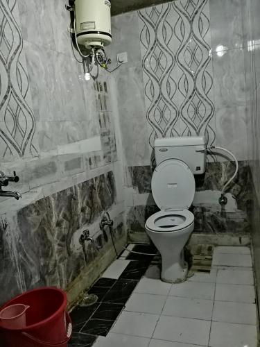 a bathroom with a toilet and a bucket in it at Royal Heritage Guest House in Jodhpur