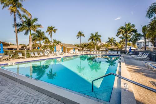 a swimming pool at a resort with palm trees at Ocean Breeze & Santa Maria Condos in Fort Myers Beach
