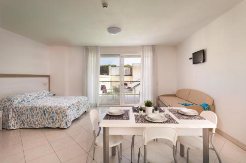 Zimmer mit einem Bett, einem Tisch und Stühlen in der Unterkunft Residence I Diamanti in Cervia