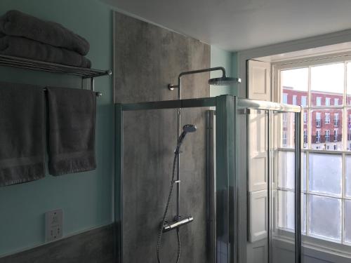 a shower stall in a bathroom with a window at Regency Rooms Guesthouse in Cheltenham