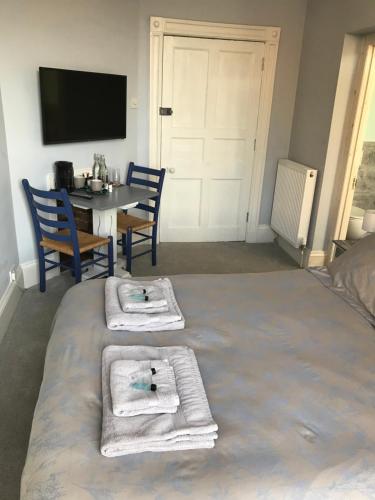 a bedroom with a bed with towels on it at Regency Rooms Guesthouse in Cheltenham