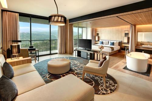 a living room with a couch and a bed at Royal Tulip Gunung Geulis Resort and Golf in Bogor