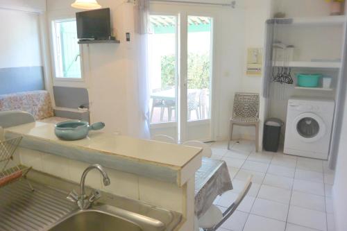 une cuisine avec un évier et une machine à laver dans l'établissement St CYPRIEN D23, à Porto-Vecchio
