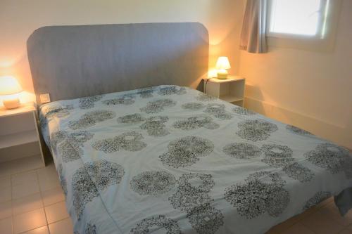 - un lit avec un couvre-lit fleuri et 2 lampes dans l'établissement St CYPRIEN D23, à Porto-Vecchio