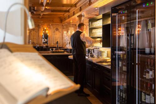 a man standing in a kitchen preparing food at Hotel MAYR in Castelrotto