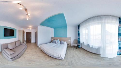 a bedroom with a bed and a couch and a window at Landgasthof Büttel in Geisfeld