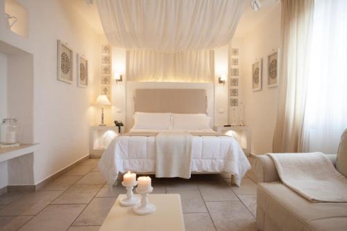 a white bedroom with a bed and a couch at Relais in Contrada in Lucera