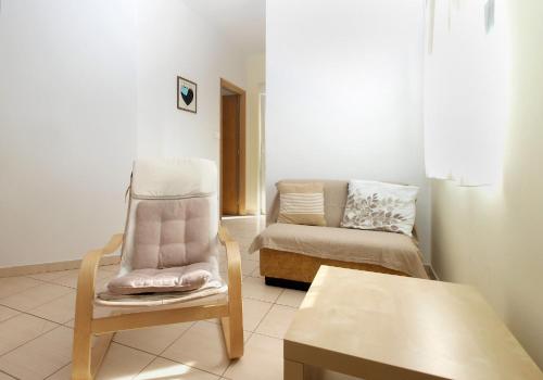 a living room with a chair and a couch at Apartments Mira 1804 in Medulin