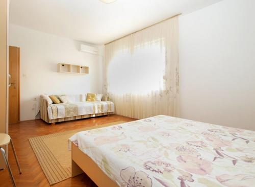 a bedroom with a bed and a window and a couch at Apartments Mira 1804 in Medulin