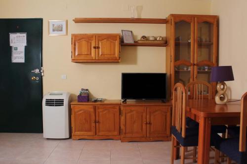 a living room with a tv and a wooden entertainment center at Apartamento Tres Carretas Puerto Real in Puerto Real