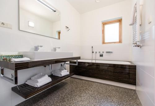 a white bathroom with a sink and a tub at Relais & Chateaux Hotel Landgoed Het Roode Koper in Ermelo