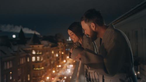 a man and woman standing on a balcony looking at a city at Lapland Hotels Bulevardi in Helsinki