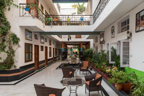 a courtyard with tables and chairs and plants at Hotel Harmony in Khajurāho